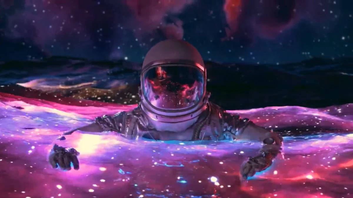 太空人 桌布 壁紙 — 一位太空人在星光燦爛的天空下漂浮在由發光粉紅色和藍色星雲組成的宇宙海洋中。