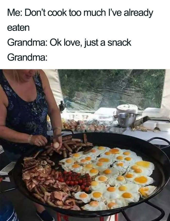 Food Memes 桌布 壁紙 — 一位女士在戶外烹飪活動中，將雞蛋加入一個裝滿香腸、培根和櫻桃番茄的巨大煎鍋中。