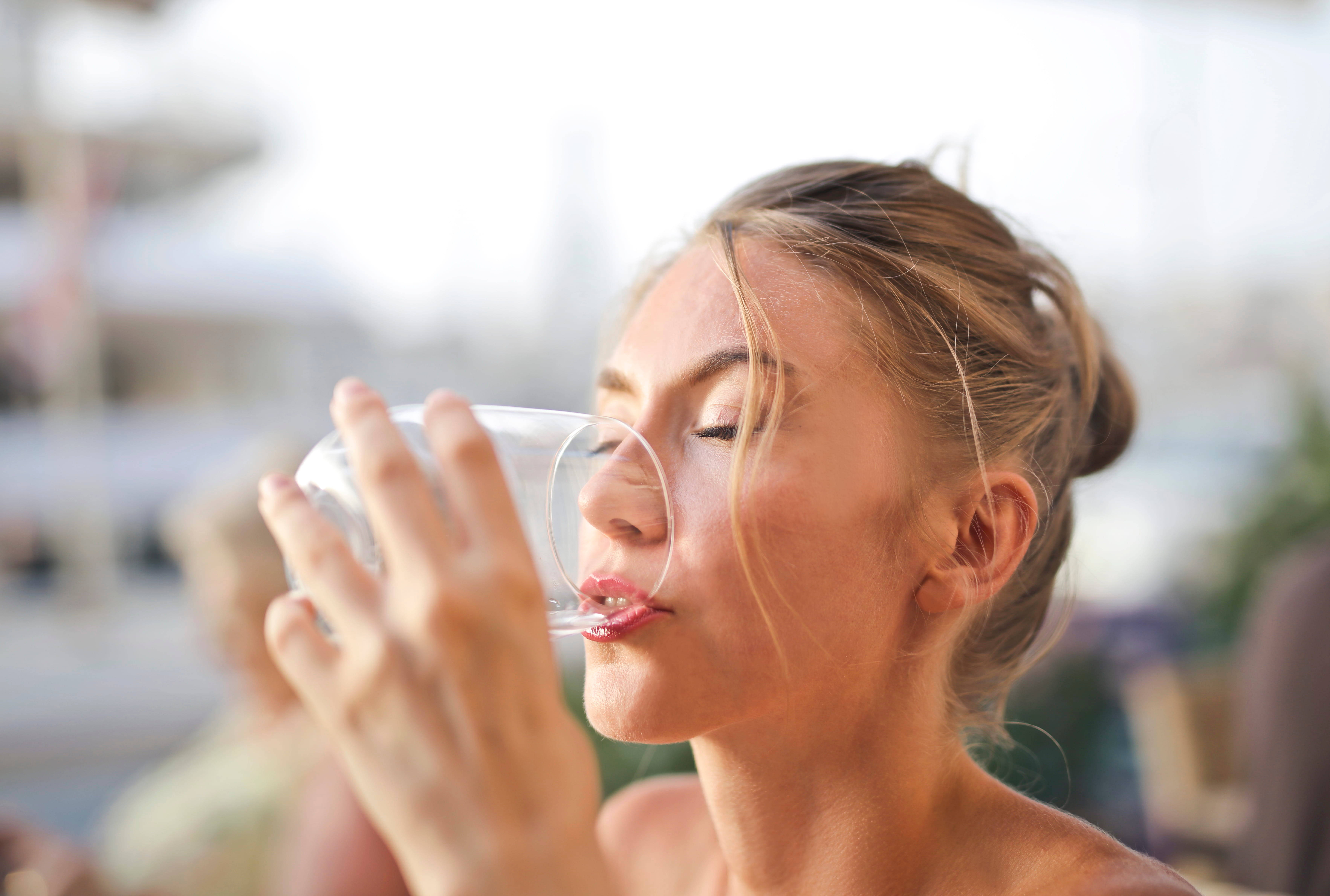 Drinking 桌布 壁紙 — 一位女士在明亮的戶外環境中閉著眼睛從透明玻璃杯喝水。