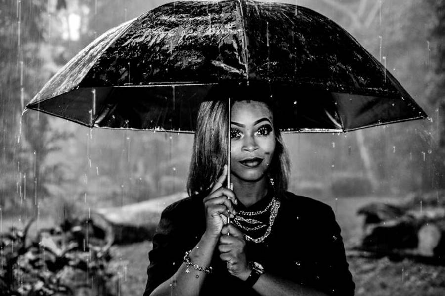 Raining 桌布 壁紙 — 一位女士在雨中撐著黑色雨傘，營造出充滿情緒的黑白肖像。