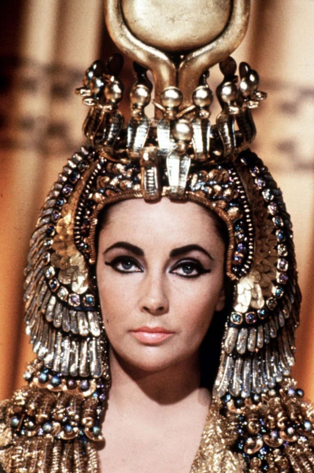 Cleopatra 桌布 壁紙 — 一位女士的近距離特寫，戴著華麗的金色埃及頭飾，飾有珠寶和金屬裝飾。