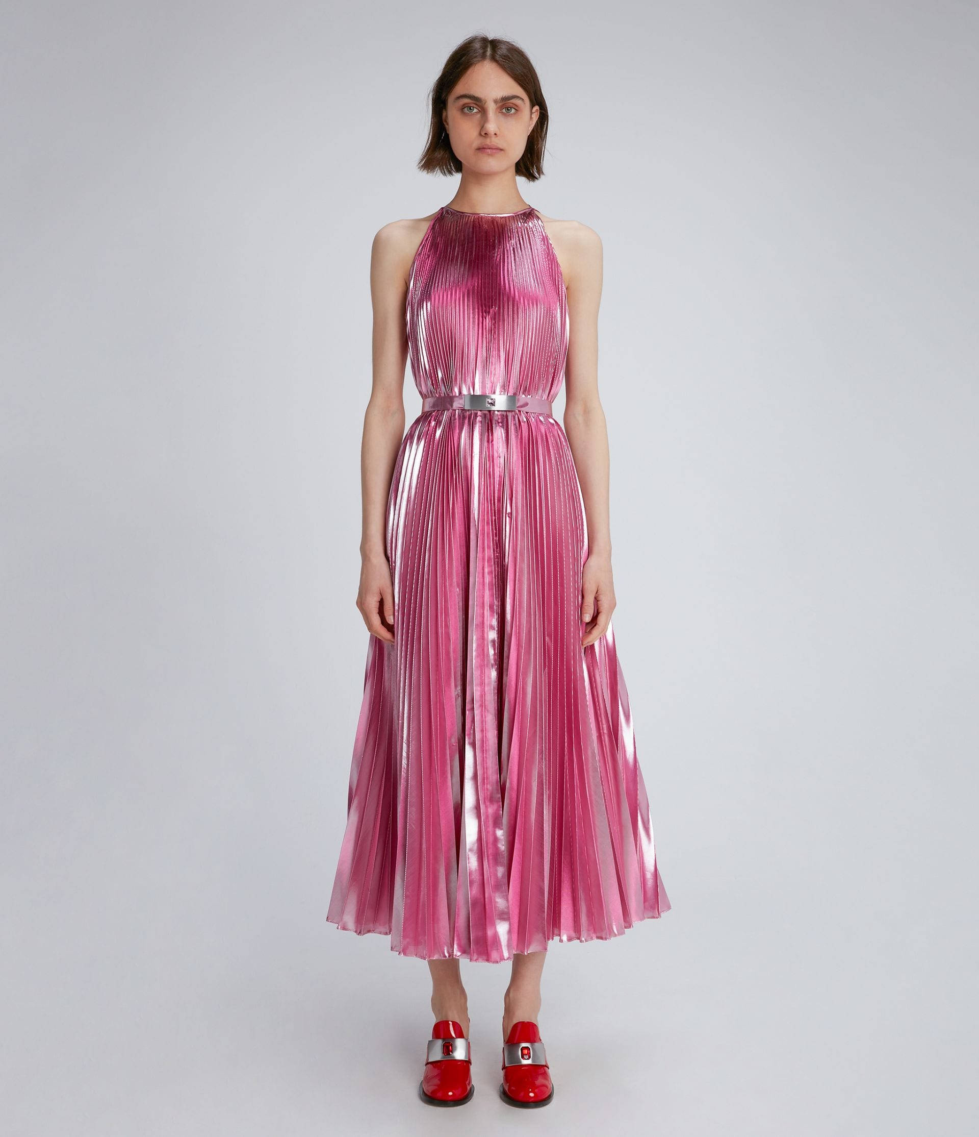 Clothes 桌布 壁紙 — 一位女士身穿閃亮粉紅色百褶裙，搭配銀色腰帶和紅色鞋子，在純灰色攝影棚背景下優雅站立。