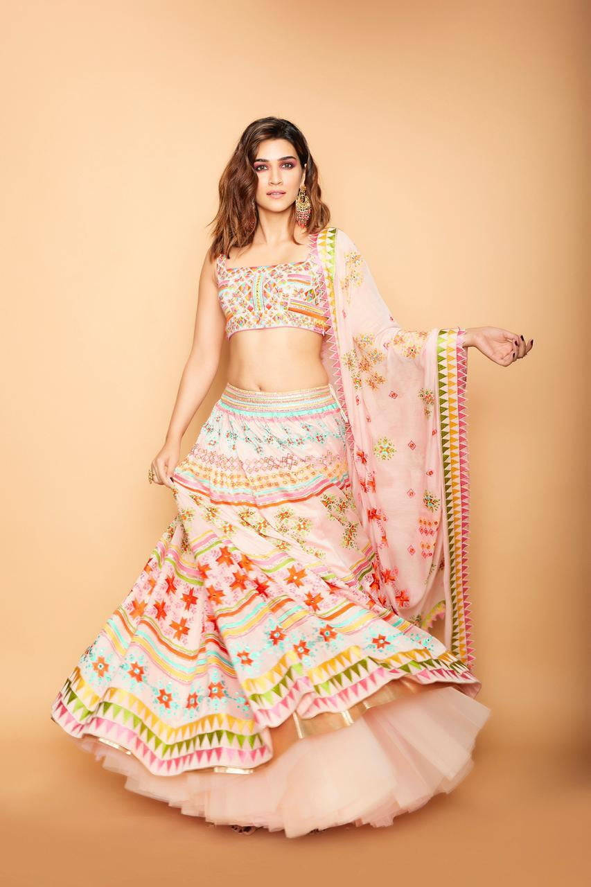 Magazine 桌布 壁紙 — 一位女士身穿鮮豔粉紅及多色刺繡的 lehenga，在純色米色攝影棚背景前優雅擺姿勢。