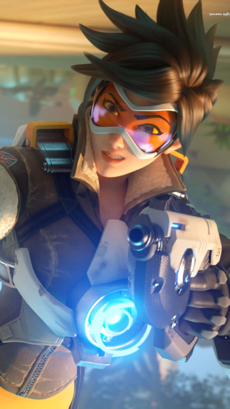 iPhone Xs Overwatch 桌布 壁紙 — 一位女性《鬥陣特攻》英雄，擁有刺刺的棕色頭髮和發光的橙色護目鏡，正瞄準一把未來風格的藍光武器。