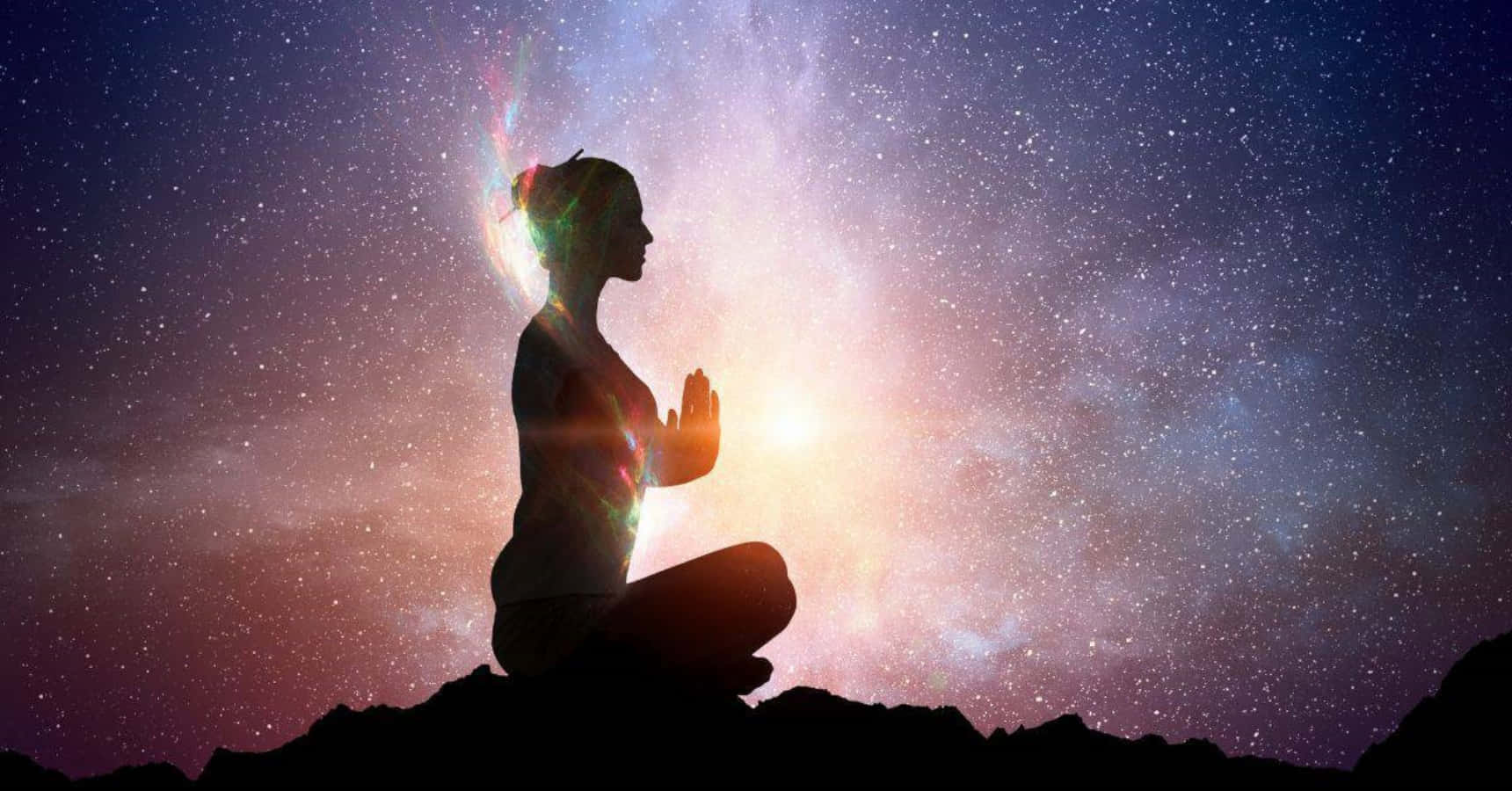 Spirituality 桌布 壁紙 — 一位女性在山頂冥想，背景是充滿活力的宇宙星系剪影。