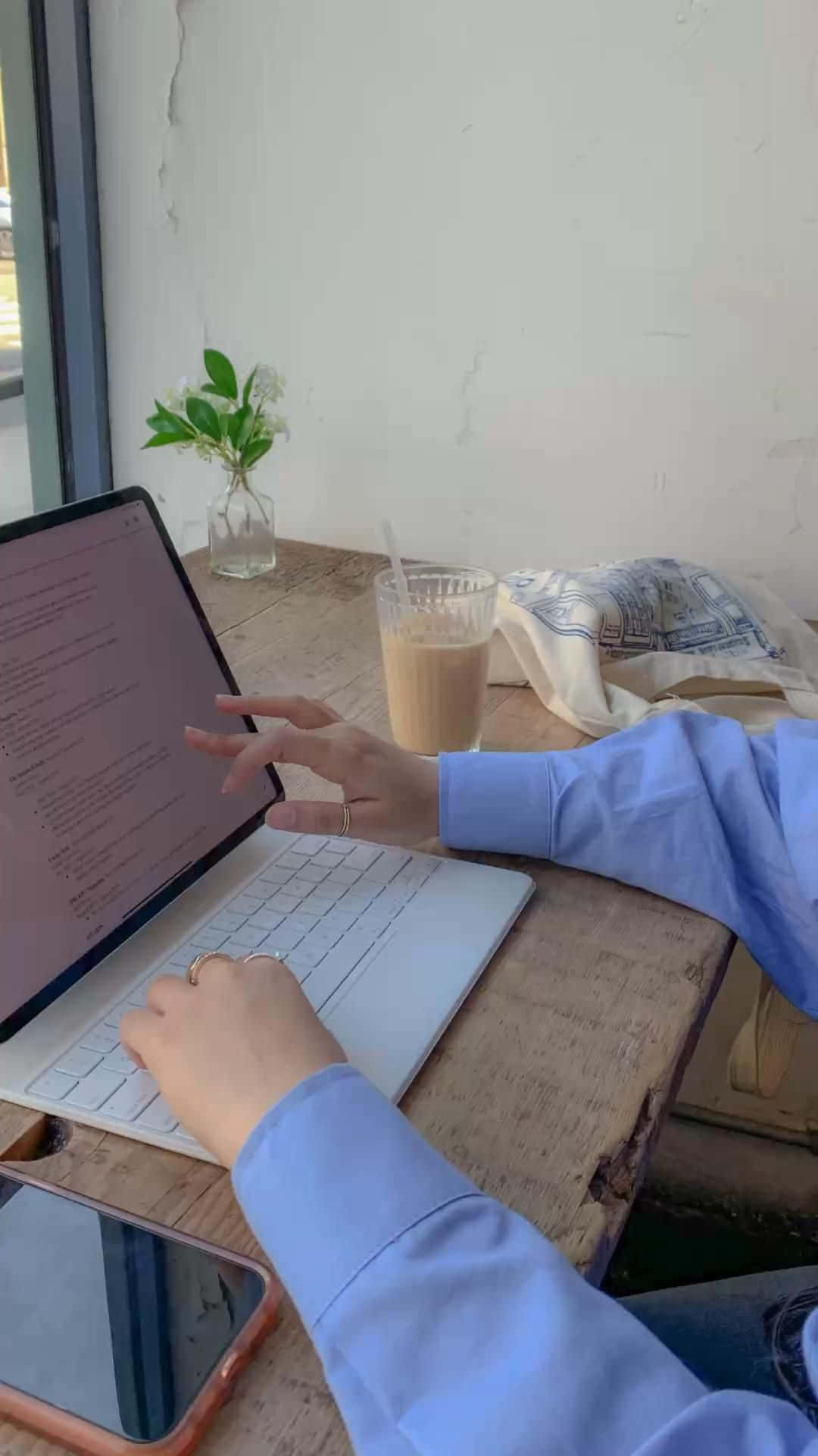 一位女性在桌前使用筆記型電腦 壁紙