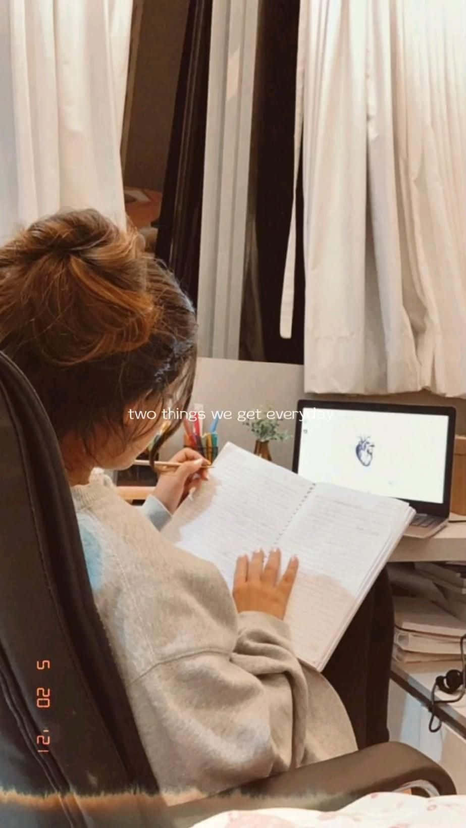 一位女性坐在椅子上，正在筆記型電腦上打字 壁紙