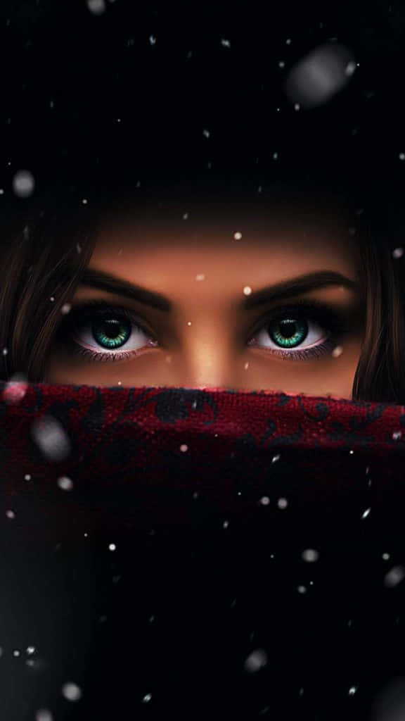 Eyes 桌布 壁紙 — 一位女性強烈的綠色眼睛透過飄落的雪花凝視，她的臉被一條紅色圖案圍巾遮蓋。