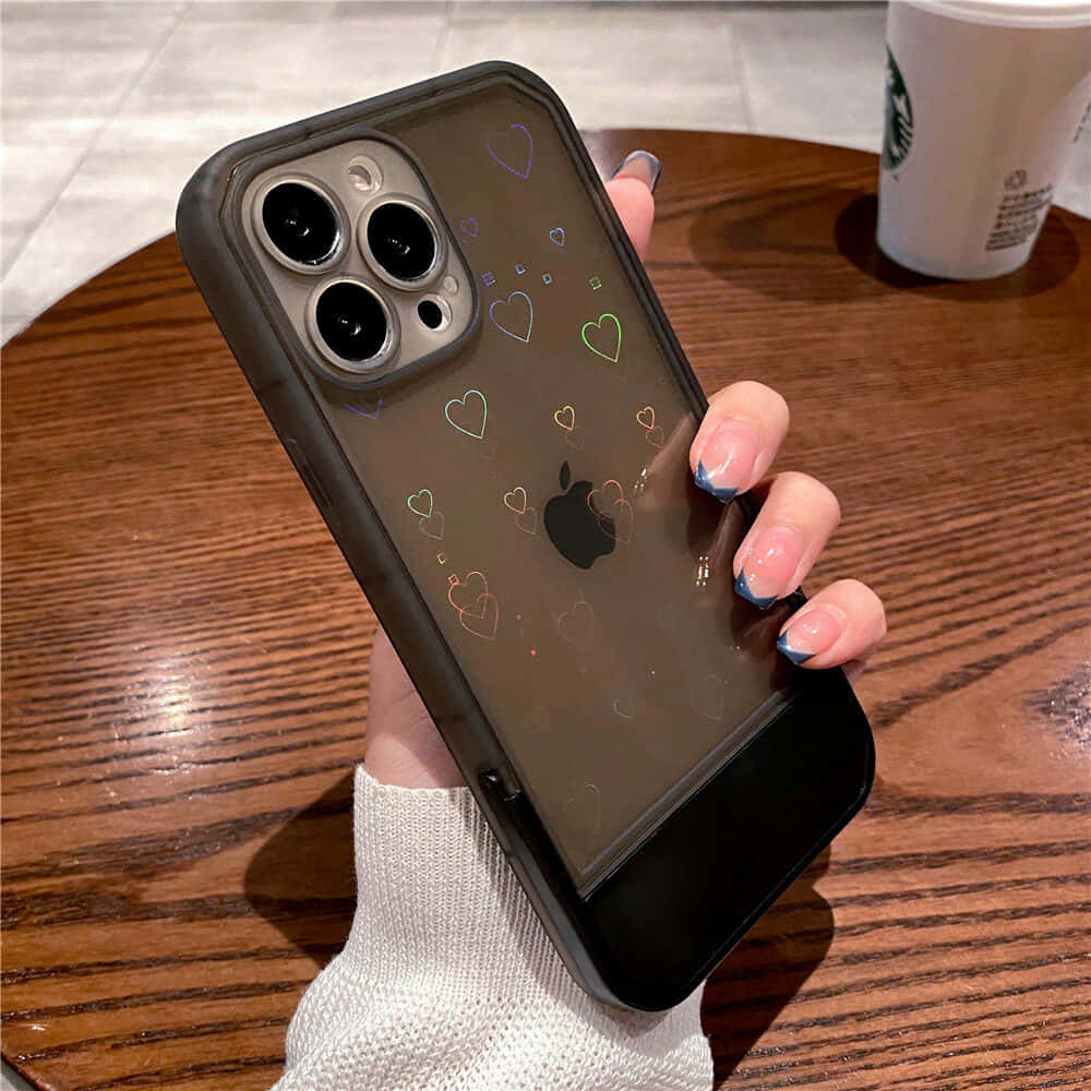 一位女性手持帶有愛心圖案的iPhone 11手機殼 壁紙