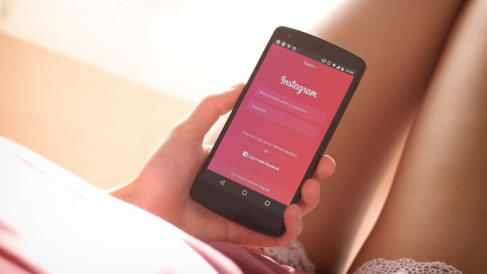 一位女性手持顯示Instagram畫面的智慧型手機 壁紙