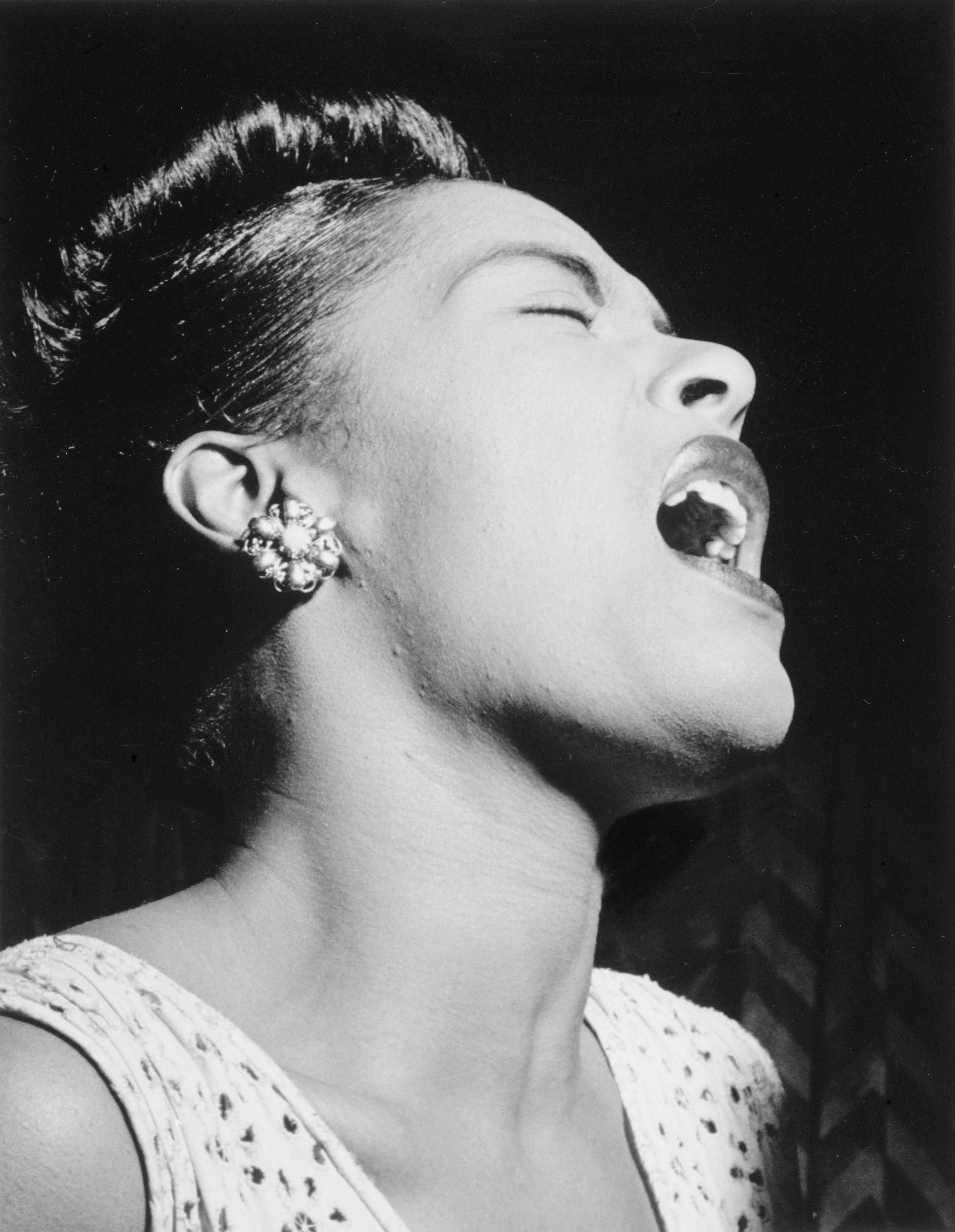 Billie Holiday 桌布 壁紙 — 一位女性閉上眼睛、頭向後傾，熱情歌唱的黑白肖像。