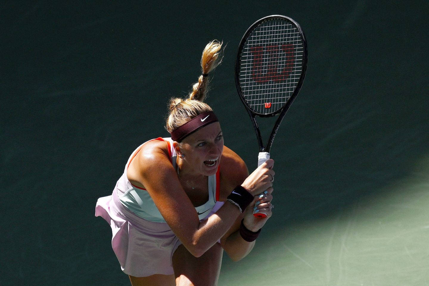 Tennis 桌布 壁紙 — 一位女網球運動員在深綠色球場背景下，以高度專注的姿態揮拍中。
