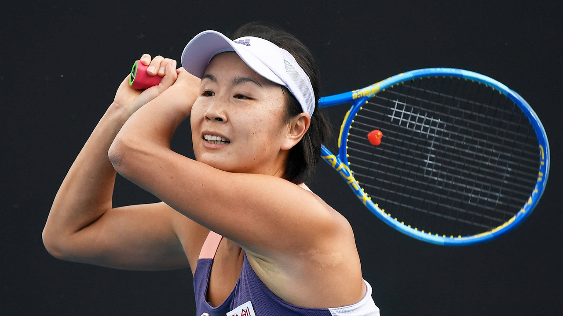Tennis 桌布 壁紙 — 一位女網球運動員在黑暗背景下以強烈專注力進行反手揮拍。