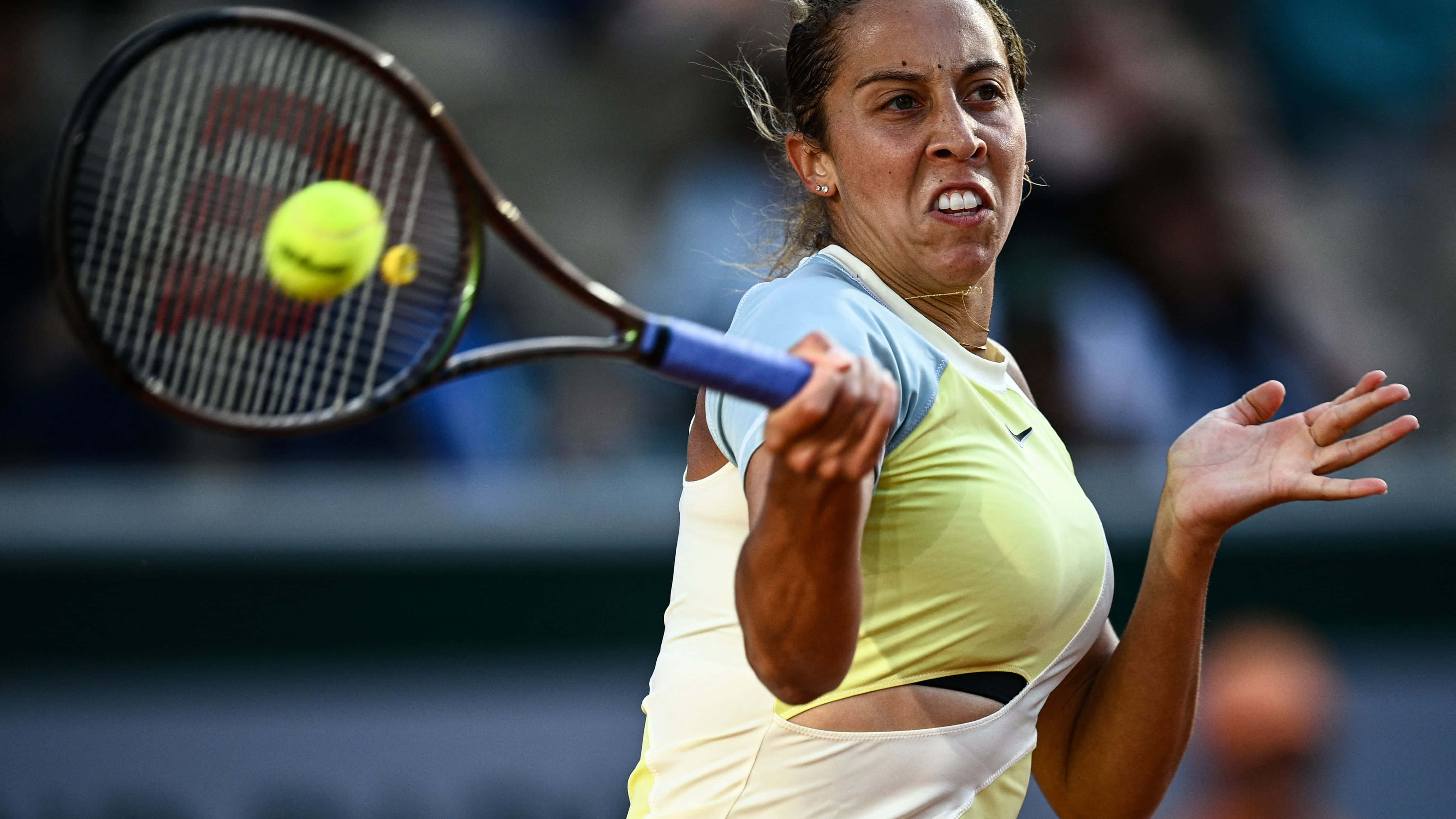 Tennis 桌布 壁紙 — 一位女網球選手在揮拍中途擊中黃色球，展現出強烈的專注力和運動力量。