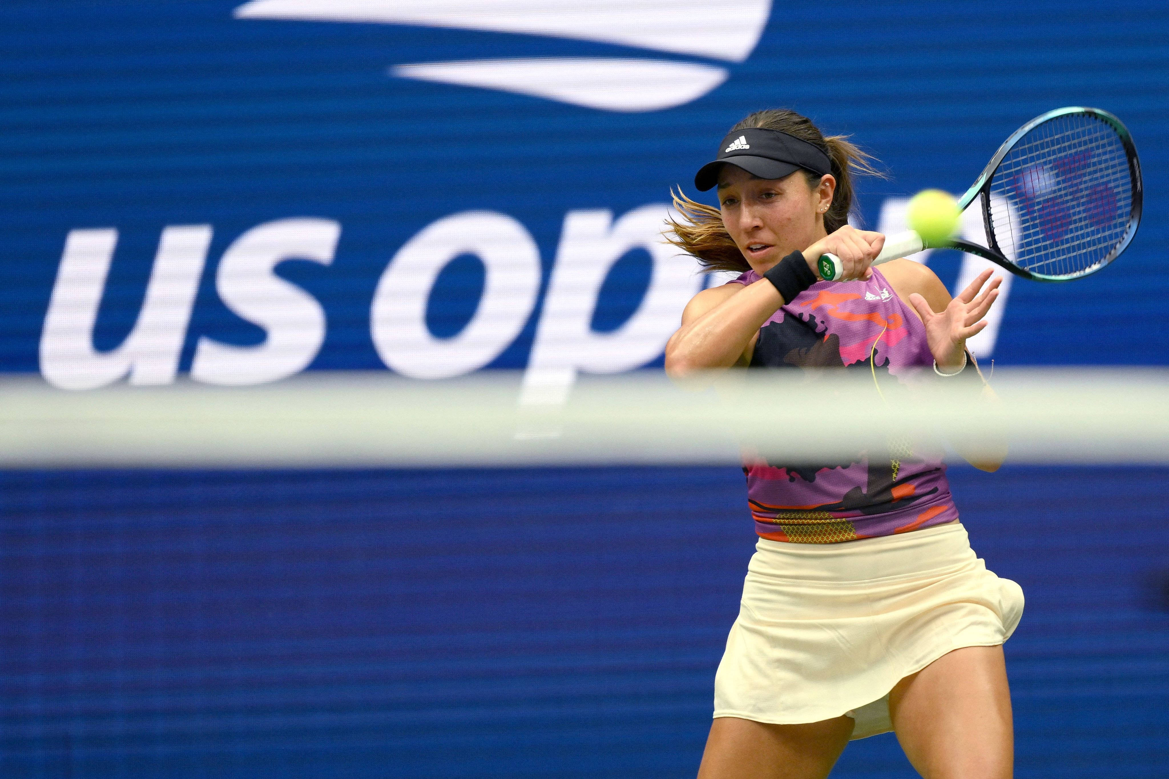 Tennis 桌布 壁紙 — 一位女網球選手在美國公開賽中，於藍色背景下揮拍擊打黃色網球。