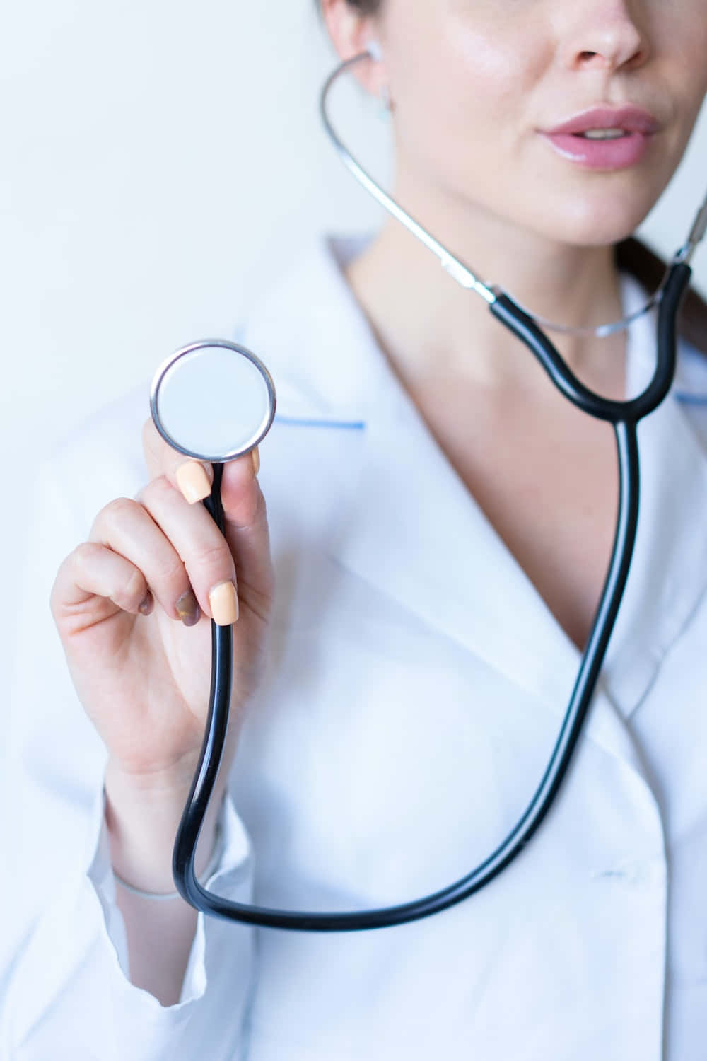 一位女醫生手持聽診器 壁紙