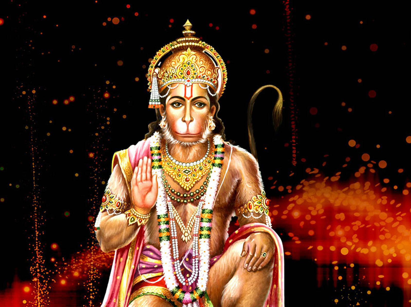 hanuman ji HD 桌布 壁紙 — 一位威嚴的猴神，佩戴金色珠寶和色彩繽紛的服飾，優雅地坐在黑暗背景中，伴隨著發光的橙色粒子。