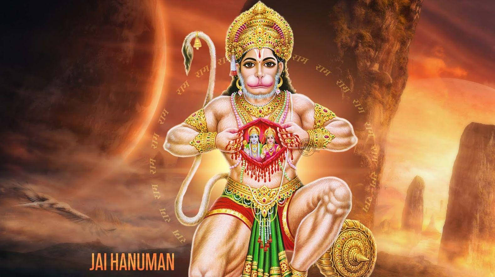 Anjaneya 桌布 壁紙 — 一位威嚴的金甲哈努曼手持神聖的心形圖標，背景是熾熱的日落和梵文文字。