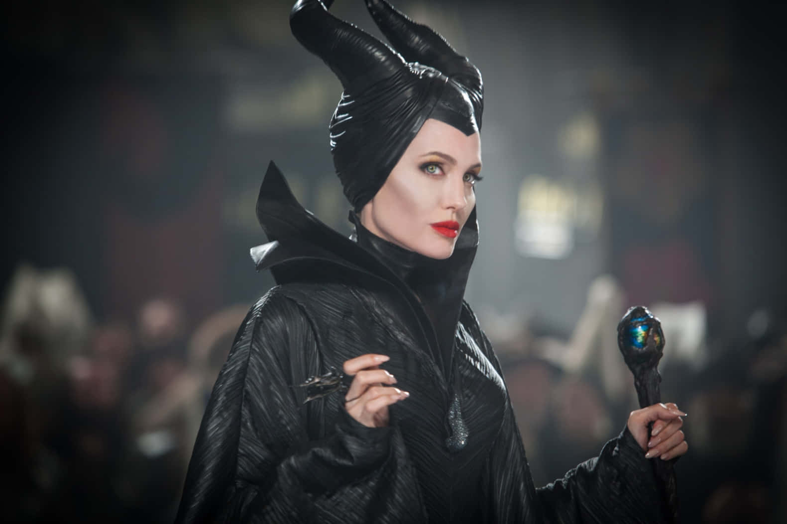 Gothic Fashion 桌布 壁紙 — 一位威嚴的黑暗女王，頭戴角狀頭飾，紅唇，在煙霧瀰漫、燈光昏暗的大廳中手持發光法杖。