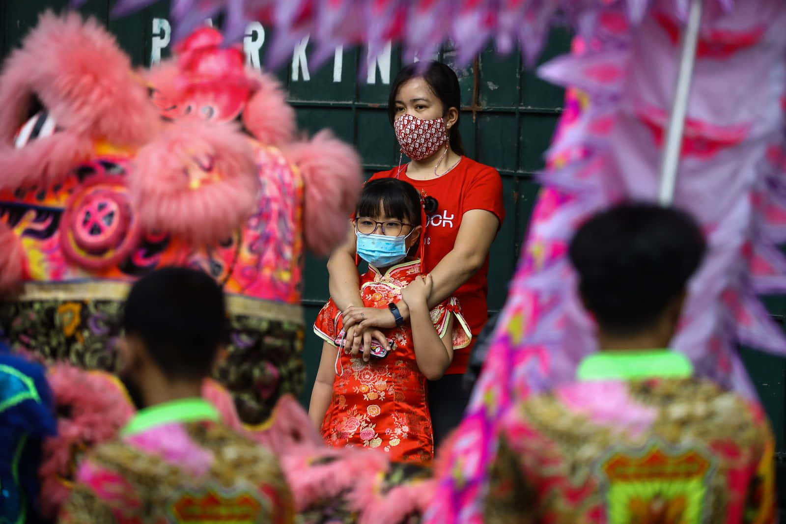 一位婦女與孩童在中國節慶中佩戴口罩 壁紙
