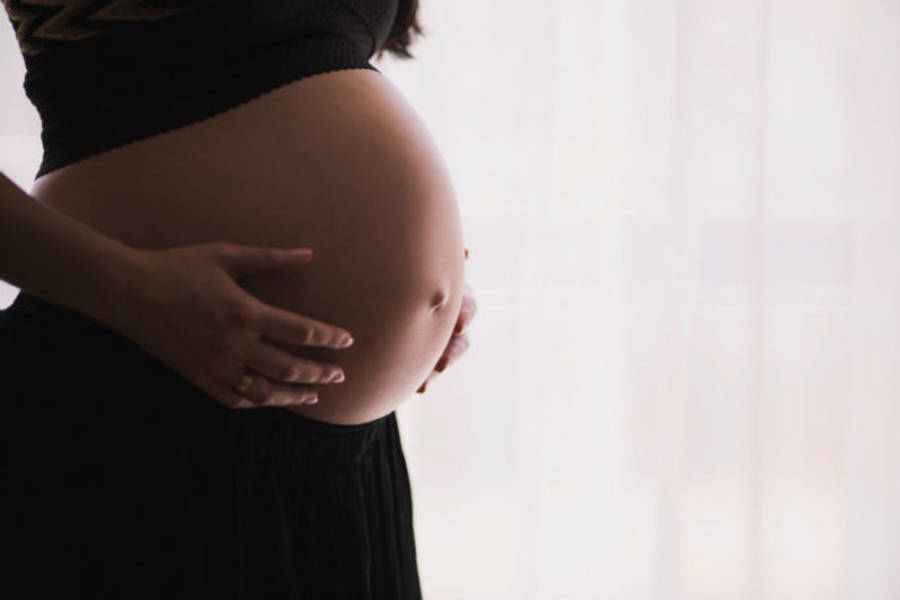 Pregnant 桌布 壁紙 — 一位孕婦在柔軟的白色窗簾背景下輕輕地抱著她圓潤的肚子。
