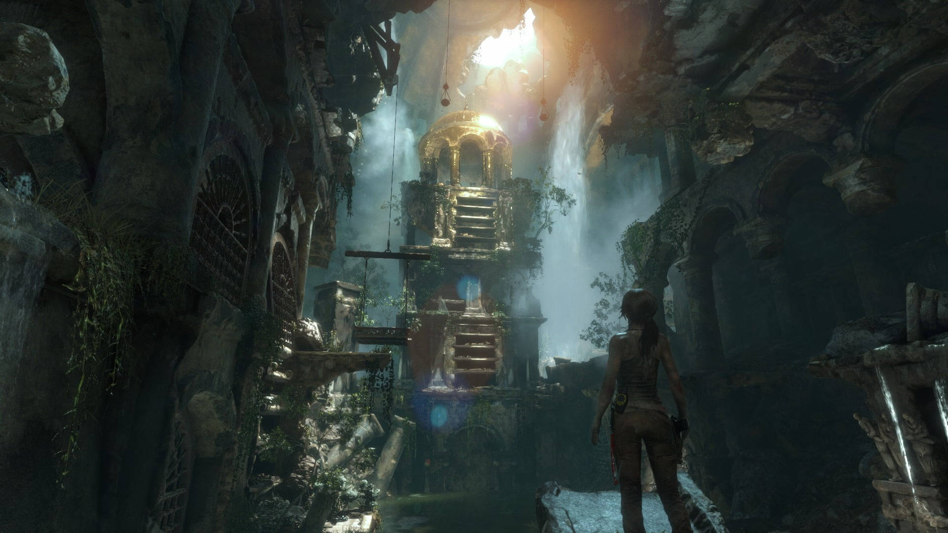 Rise Of The Tomb Raider 桌布 壁紙 — 一位孤獨的冒險家站在迷霧籠罩的古老廢墟中，仰望由瀑布懸掛的發光金色神殿。
