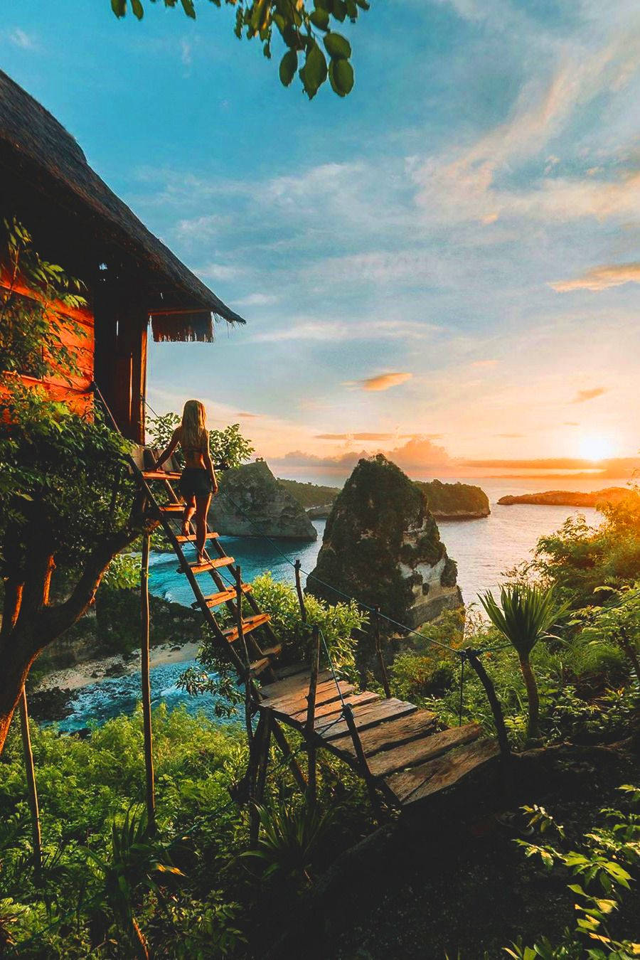 Vacation 桌布 壁紙 — 一位孤獨的旅行者從茅草屋爬上木梯，朝向碧綠海水和岩石島嶼上令人驚嘆的日落。