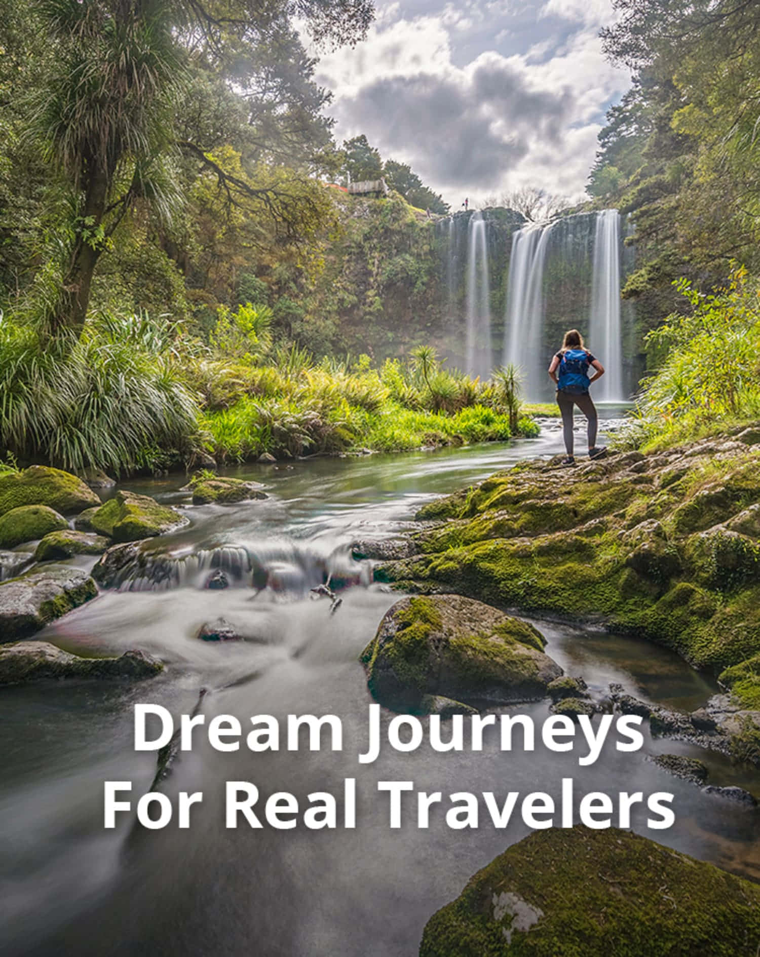Travel Desktop 桌布 壁紙 — 一位孤獨的旅行者站在長滿苔蘚的岩石上，凝視著在陰天天空下，從茂密綠色叢林中傾瀉而下的壯麗瀑布。