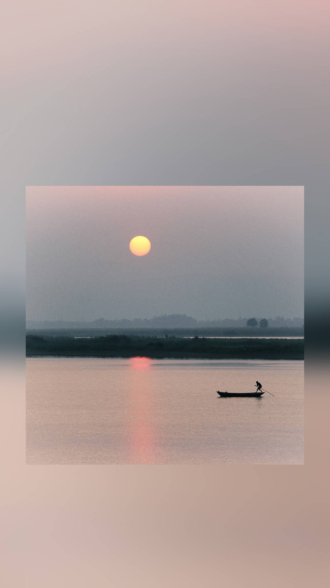 夏天 桌布 壁紙 — 一位孤獨的漁夫划著小船穿過平靜的河流，夕陽在朦朧的天空中落下，散發出溫暖的光芒。