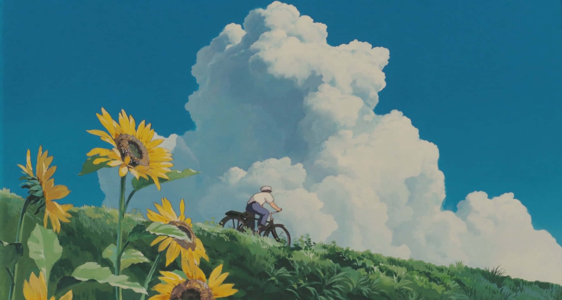 Aesthetic Ghibli 桌布 壁紙 — 一位孤獨的自行車騎士踩著腳踏車上坡，穿過向日葵田，頭頂是廣闊的天空和戲劇性的白雲。