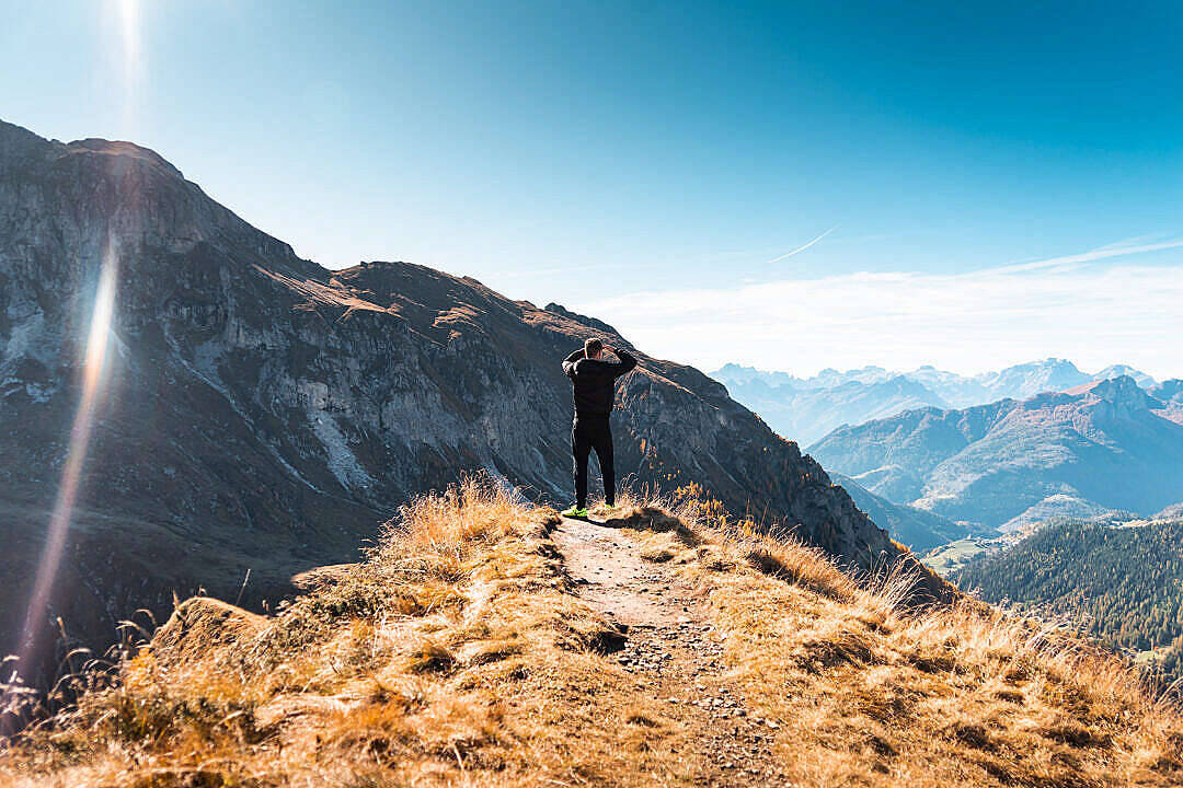 遠足者在山脊上享受燦爛陽光下的高山全景。 — 單身男孩 壁紙