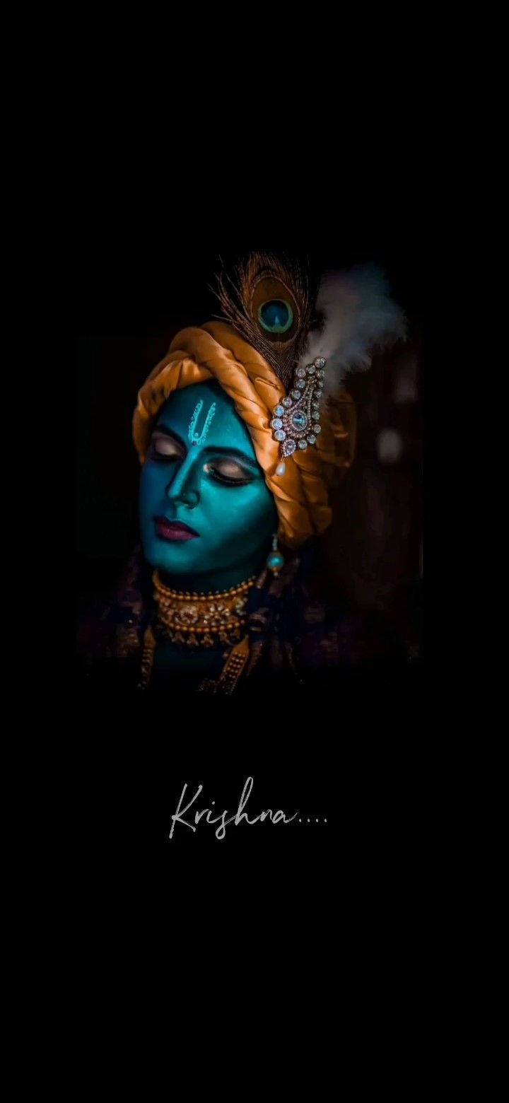 krishna iPhone 桌布 壁紙 — 一位寧靜的藍皮膚神祇，閉著雙眼，佩戴金色珠寶和孔雀羽毛頭巾，背景為深色。
