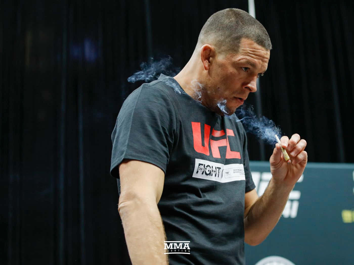 UFC 桌布 壁紙 — 一位專注的MMA拳手在昏暗的健身房環境中，手持香煙呼出煙霧。