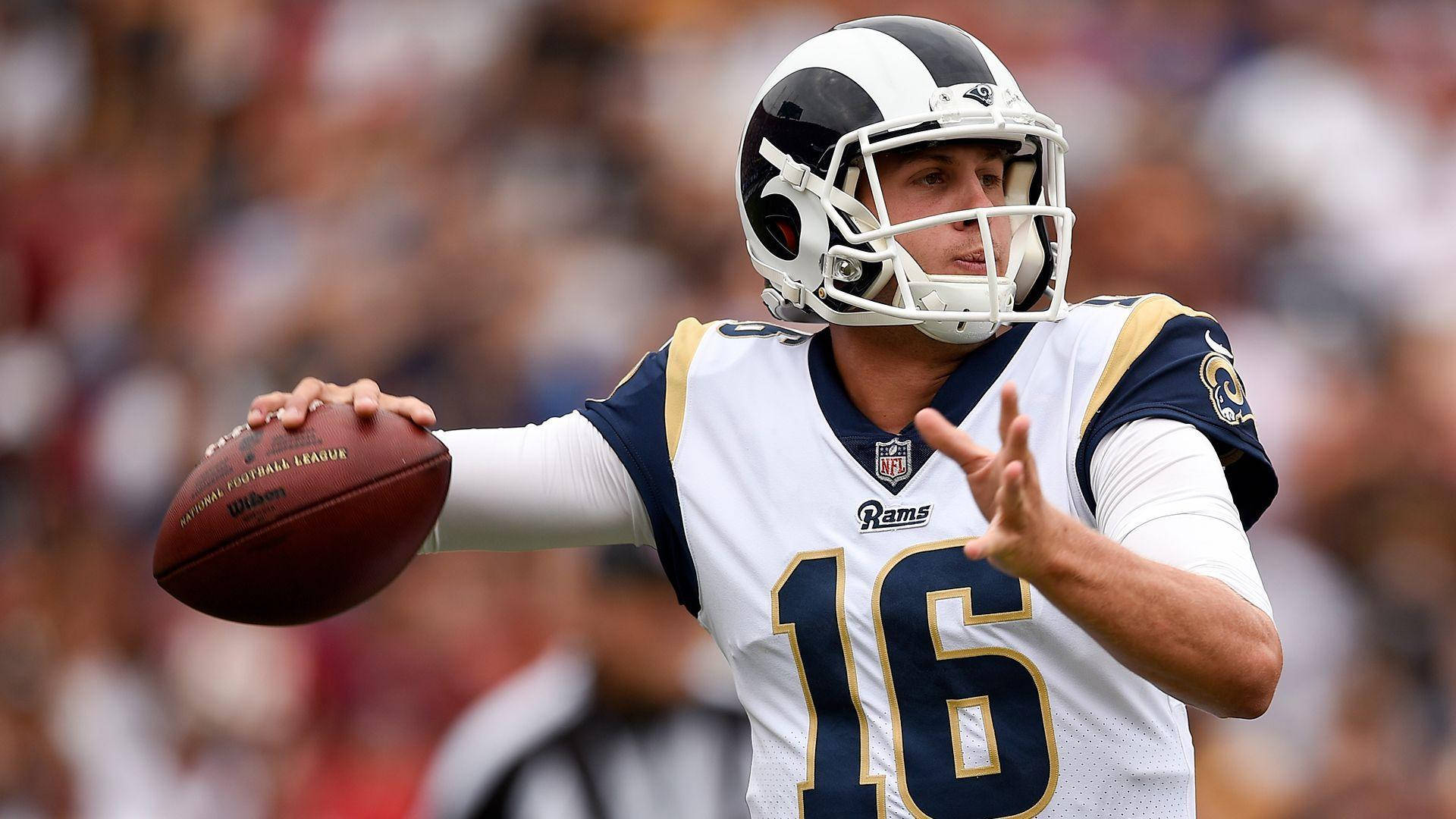 運動 桌布 壁紙 — 一位專注的NFL四分衛身穿白色公羊隊16號球衣，在日間比賽中準備擲出橄欖球。