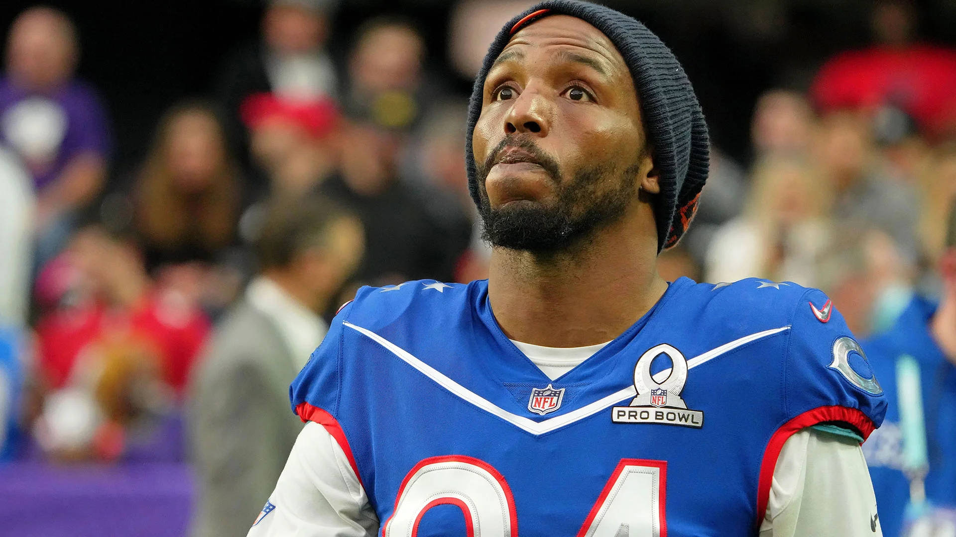 桌布 壁紙 — 一位專注的NFL球員身穿藍色Pro Bowl球衣，在球場燈光下比賽時向上凝視，神情專注。