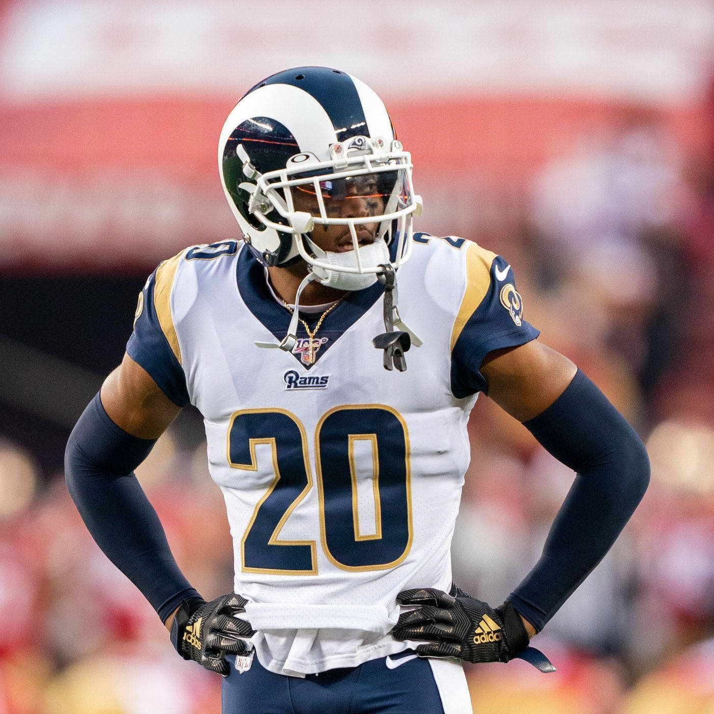 Ramsey 桌布 壁紙 — 一位專注的NFL美式足球員，身穿白色和金色的公羊隊20號球衣，雙手叉腰站在模糊的體育場地上。
