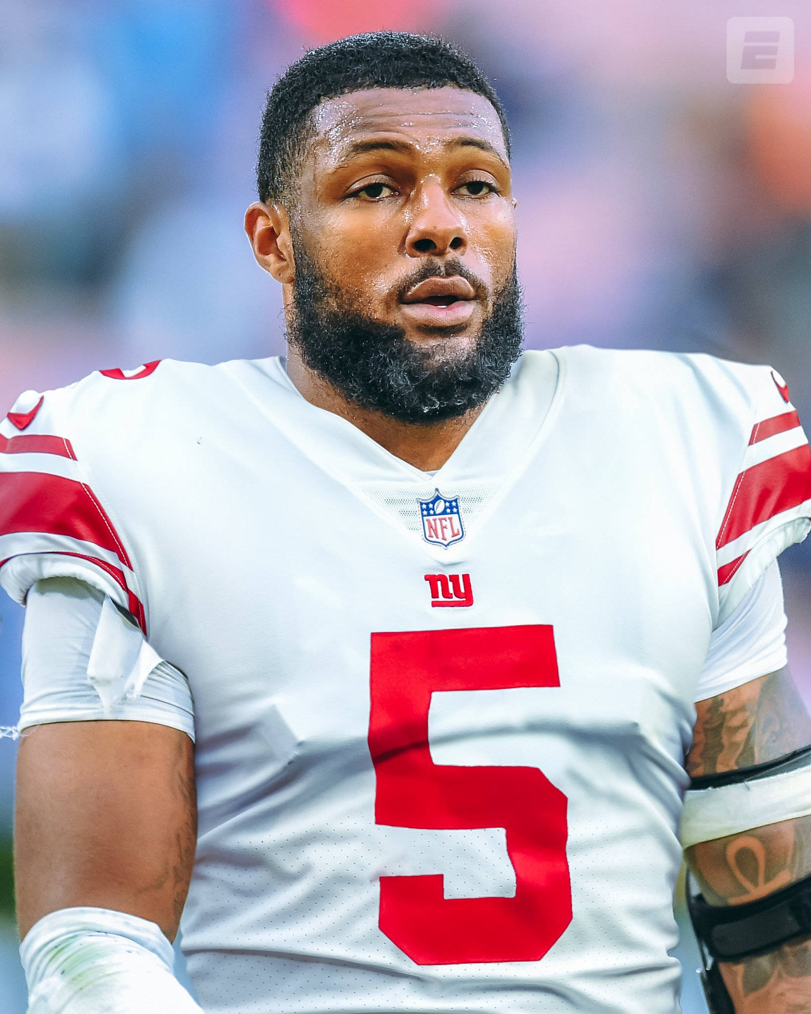 運動 桌布 壁紙 — 一位專注的NFL美式足球員特寫，身穿白色球衣，上面有紅色五號和球隊標誌。