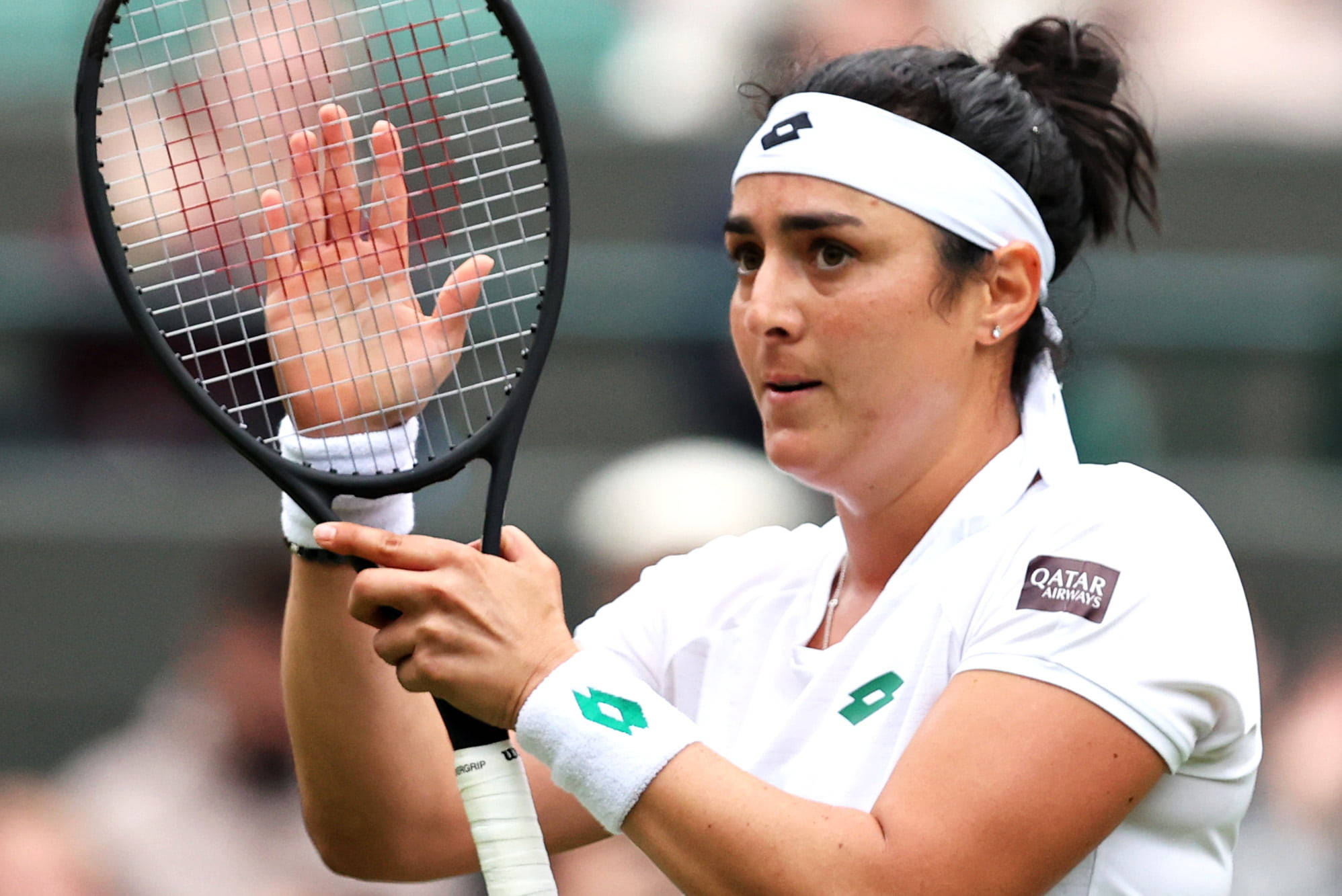 Tennis 桌布 壁紙 — 一位專注的女性網球選手在草地上向觀眾揮手，同時握著球拍。