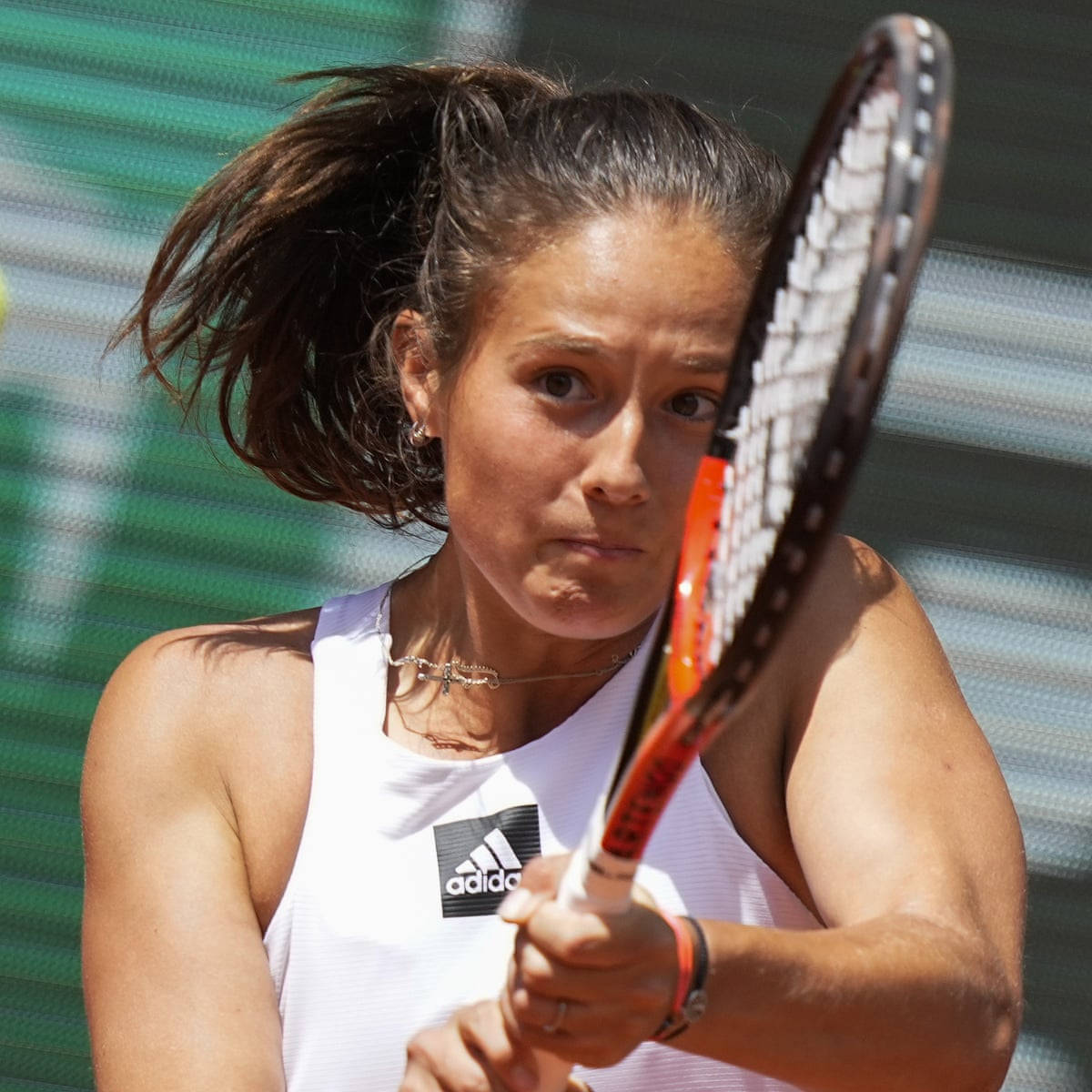 Athletic 桌布 壁紙 — 一位專注的女網球運動員在揮拍中，頭髮被風吹起，眼神凌厲，背景是綠色球場。