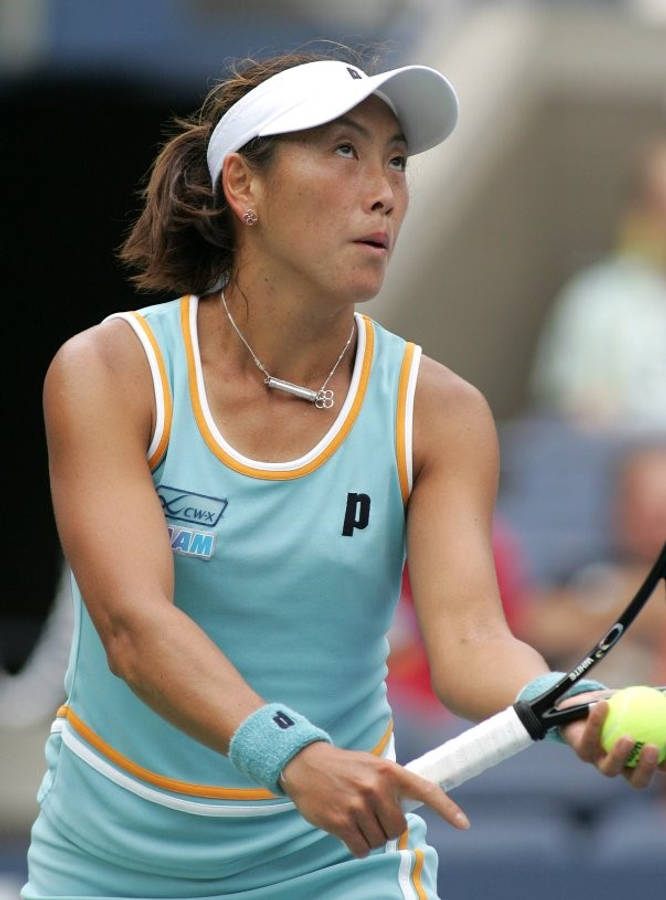 Athlete 桌布 壁紙 — 一位專注的女網球運動員穿著淺藍色和黃色服裝，準備用球拍擊打明亮的黃色網球。