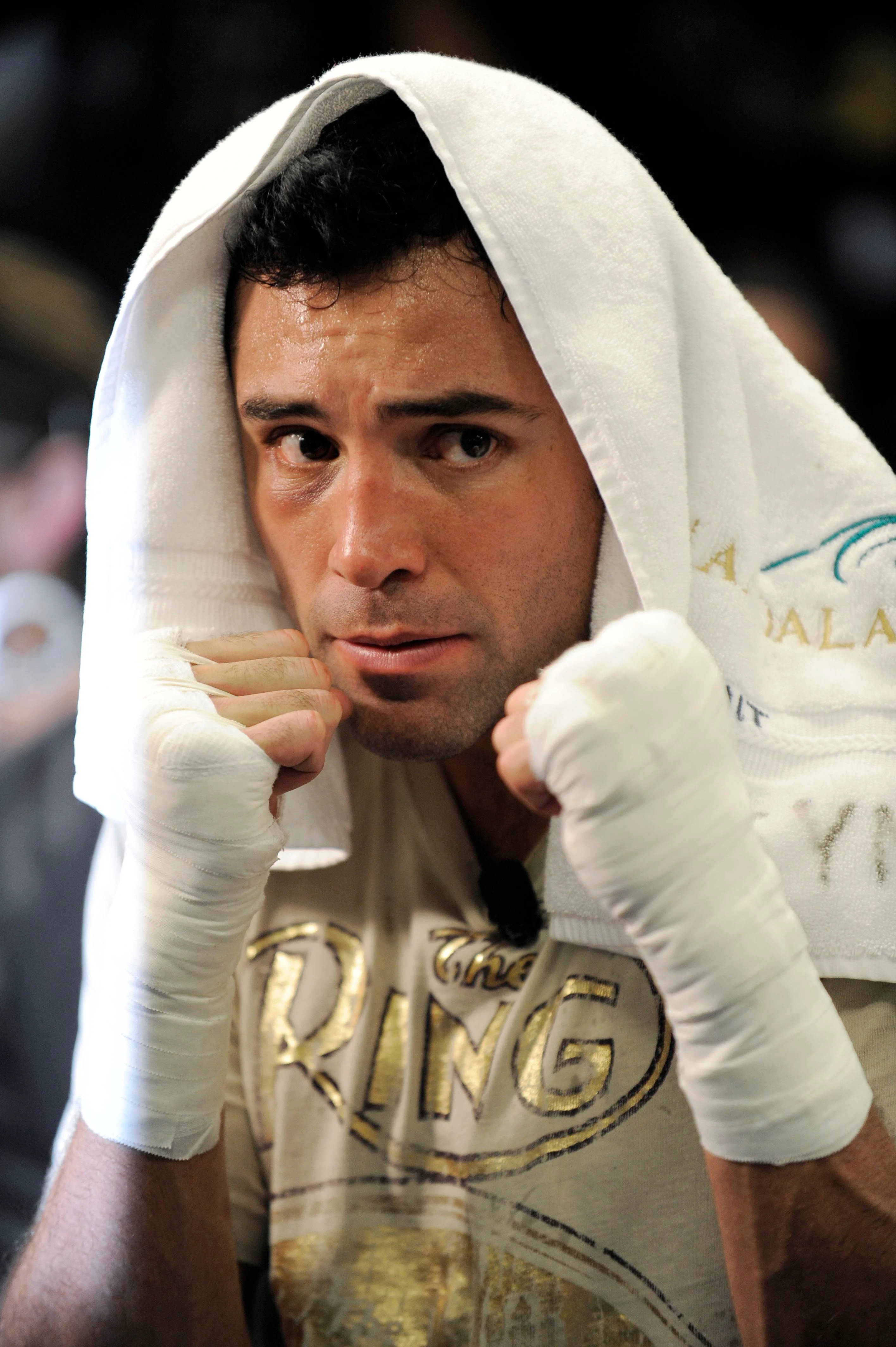 Boxing 桌布 壁紙 — 一位專注的拳擊手，頭上披著白色毛巾，雙手纏著繃帶，凝視著鏡頭。