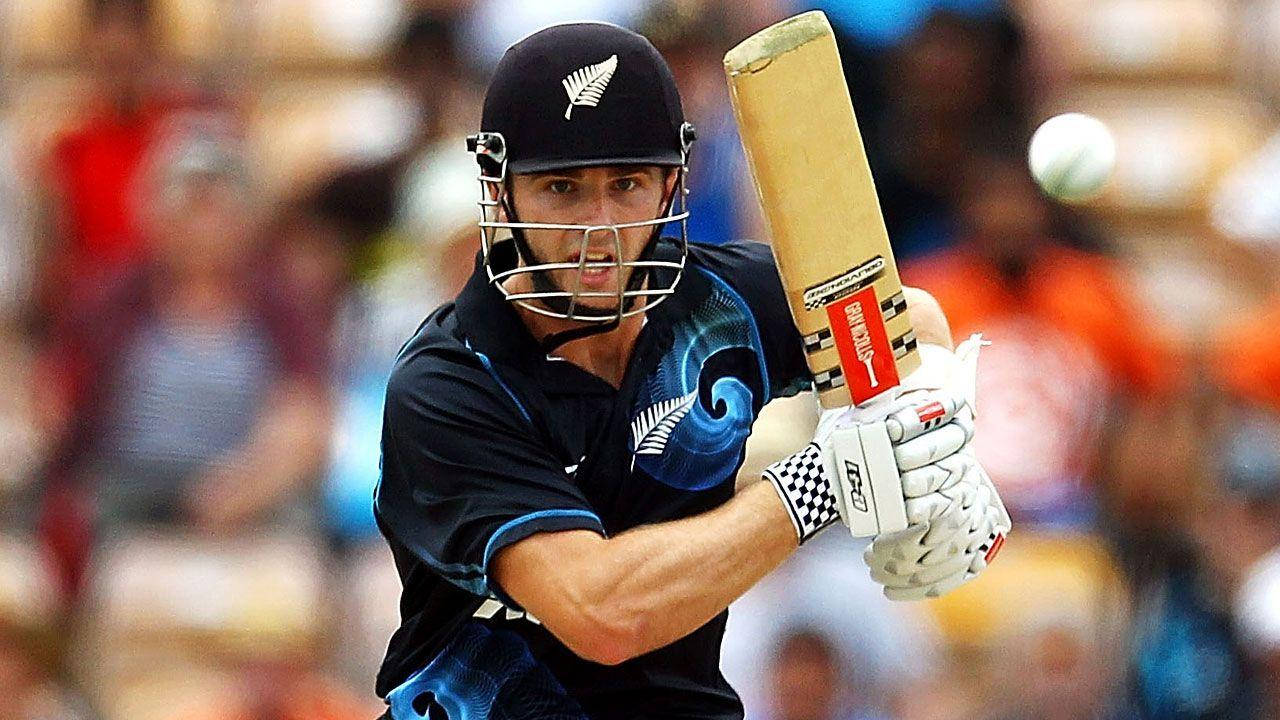 kane williamson 桌布 壁紙 — 一位專注的新西蘭板球擊球手，身穿黑色裝備，在日間比賽中揮動球棒擊打白色球。