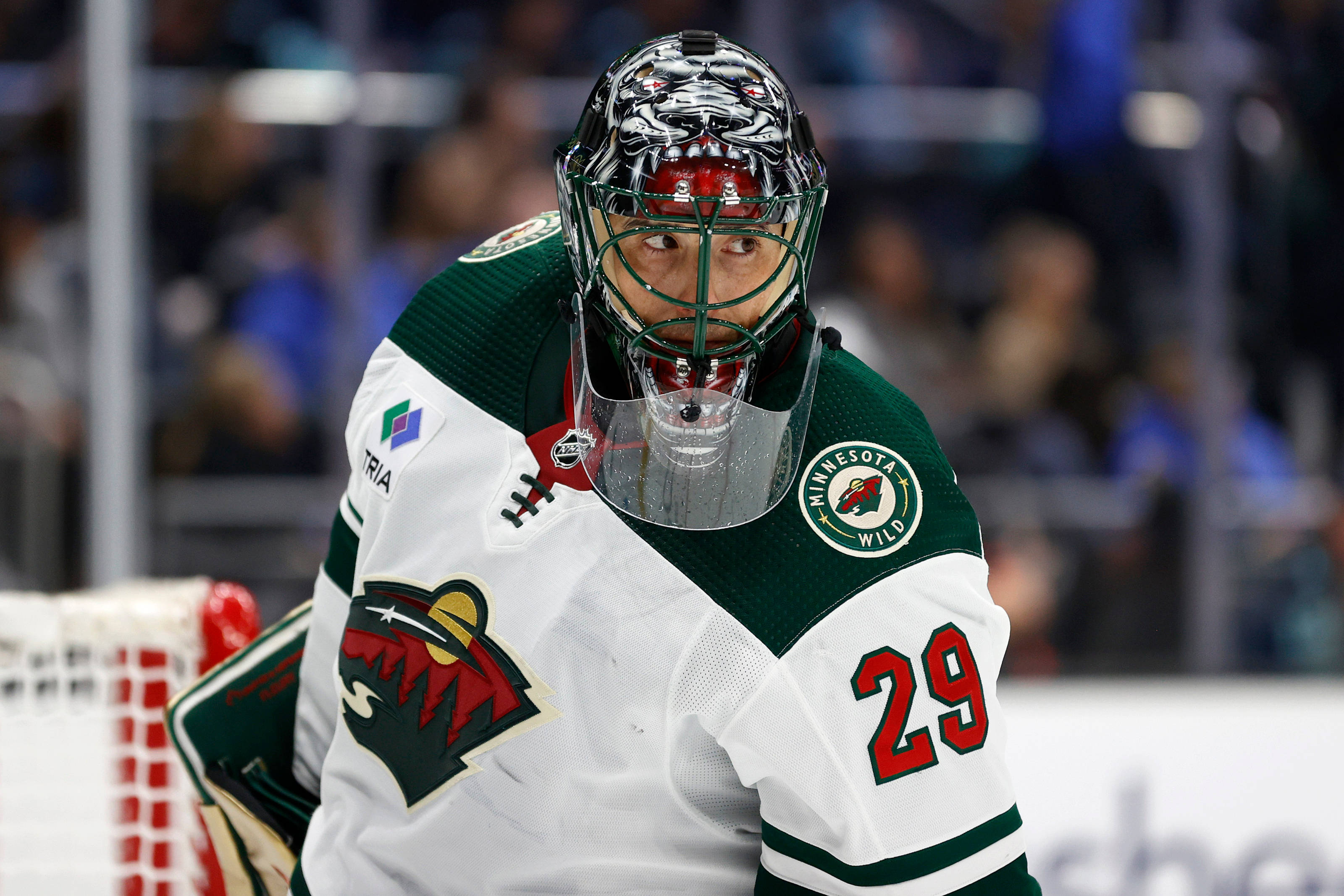 hockey 桌布 壁紙 — 一位專注的明尼蘇達荒野冰球守門員，身穿白色和綠色裝備，背號29，在比賽中凝視著。