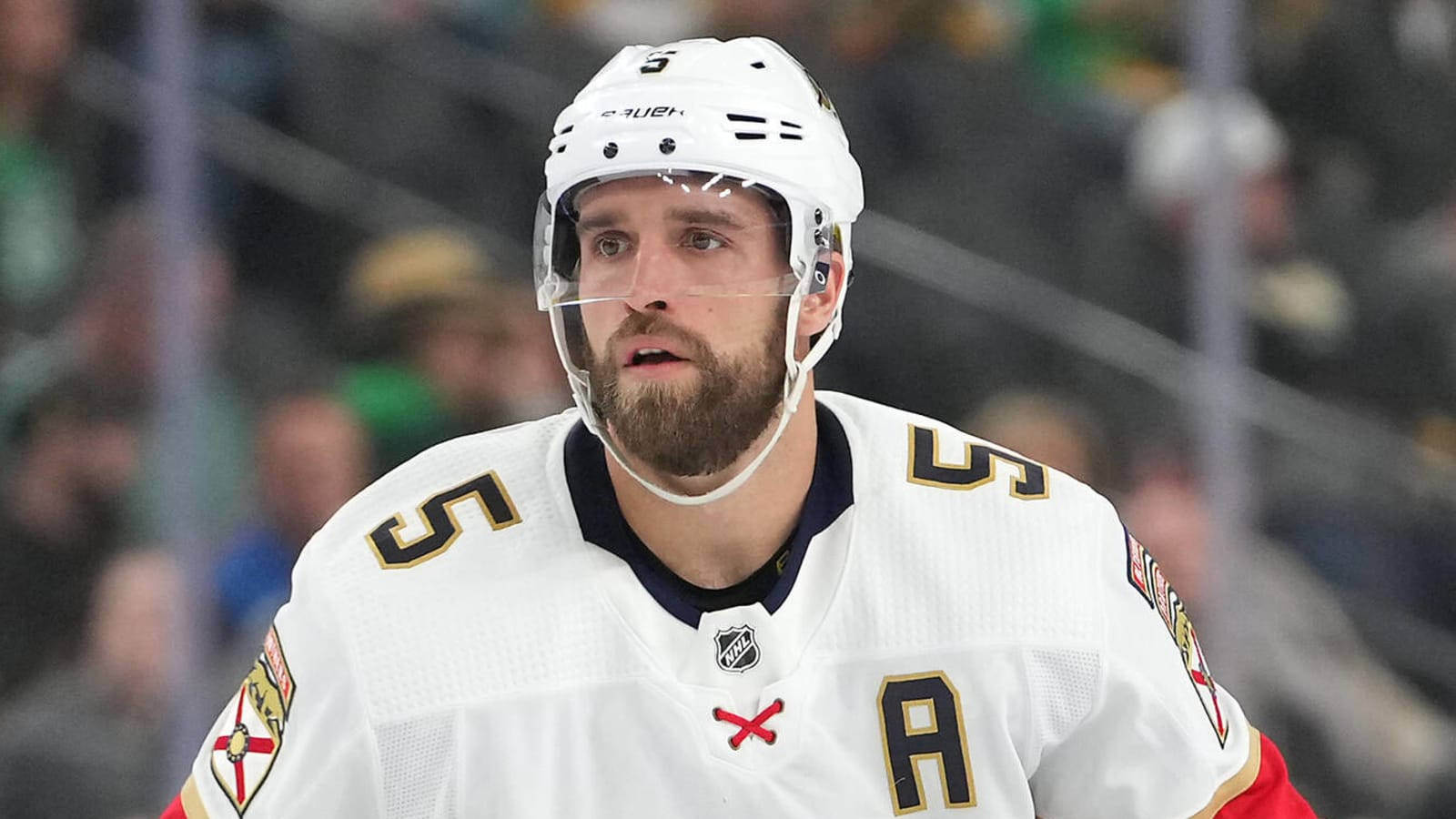 hockey 桌布 壁紙 — 一位專注的曲棍球運動員，身穿白色球衣，號碼5和字母A，在比賽中站在冰上。