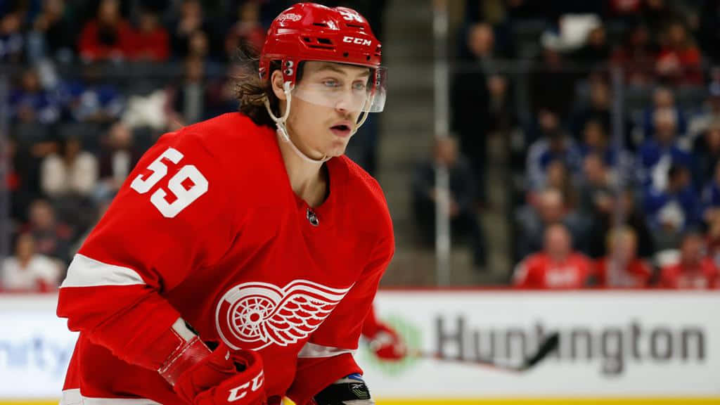 Tyler Bertuzzi 桌布 壁紙 — 一位專注的曲棍球運動員穿著紅色底特律紅翼隊59號球衣，在比賽中在冰上激烈滑行。