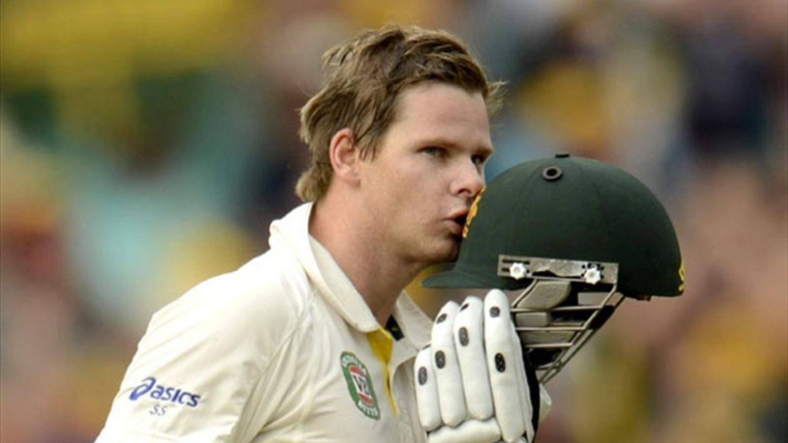 Steve Smith 桌布 壁紙 — 一位專注的板球運動員身穿白色制服，手持綠色頭盔，在陽光明媚的球場上專注地向前看。