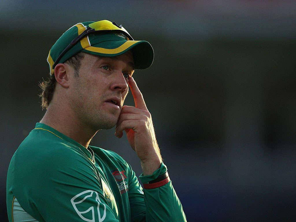 Ab De Villiers 桌布 壁紙 — 一位專注的板球運動員身穿綠色制服，帶著沉思的表情觸摸太陽穴。