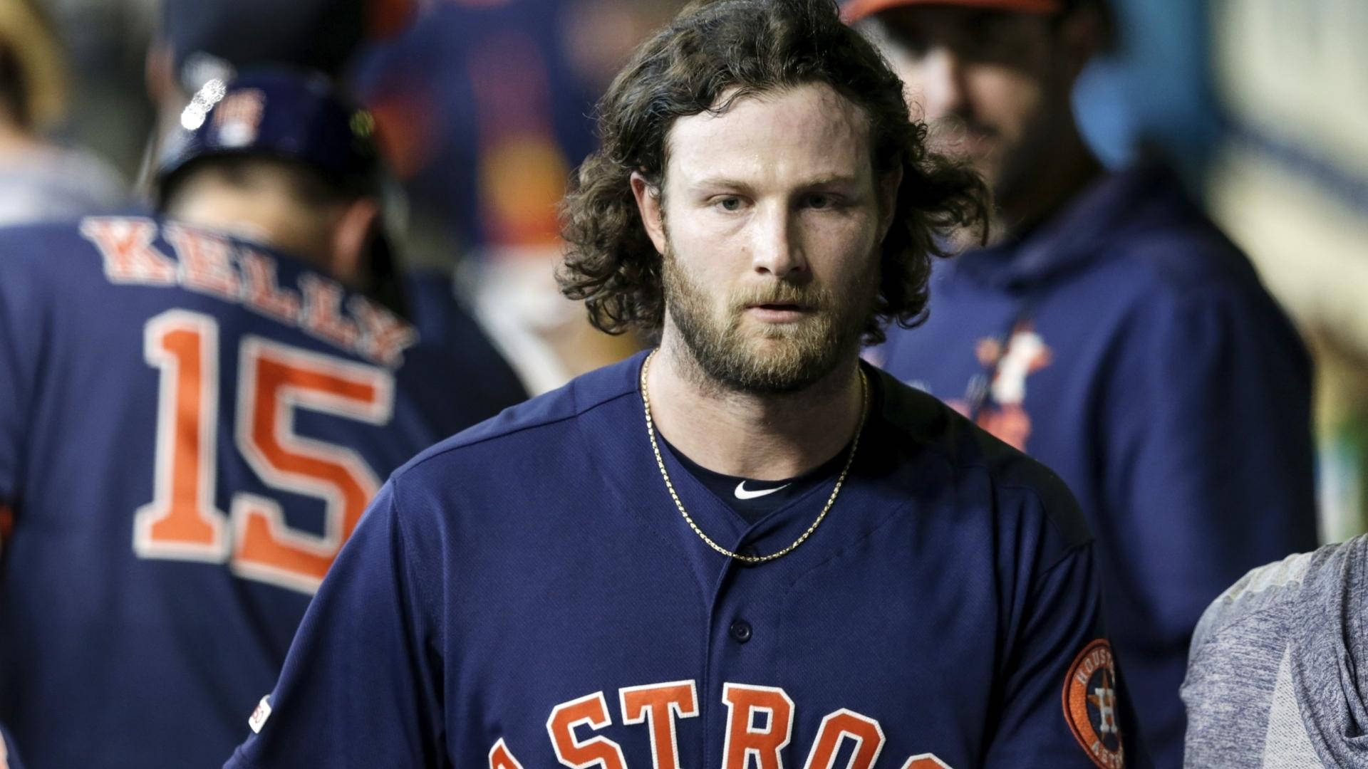 Gerrit Cole 桌布 壁紙 — 一位專注的棒球運動員，捲髮和鬍鬚，穿著休士頓太空人球衣，在球員休息區內凝視前方。