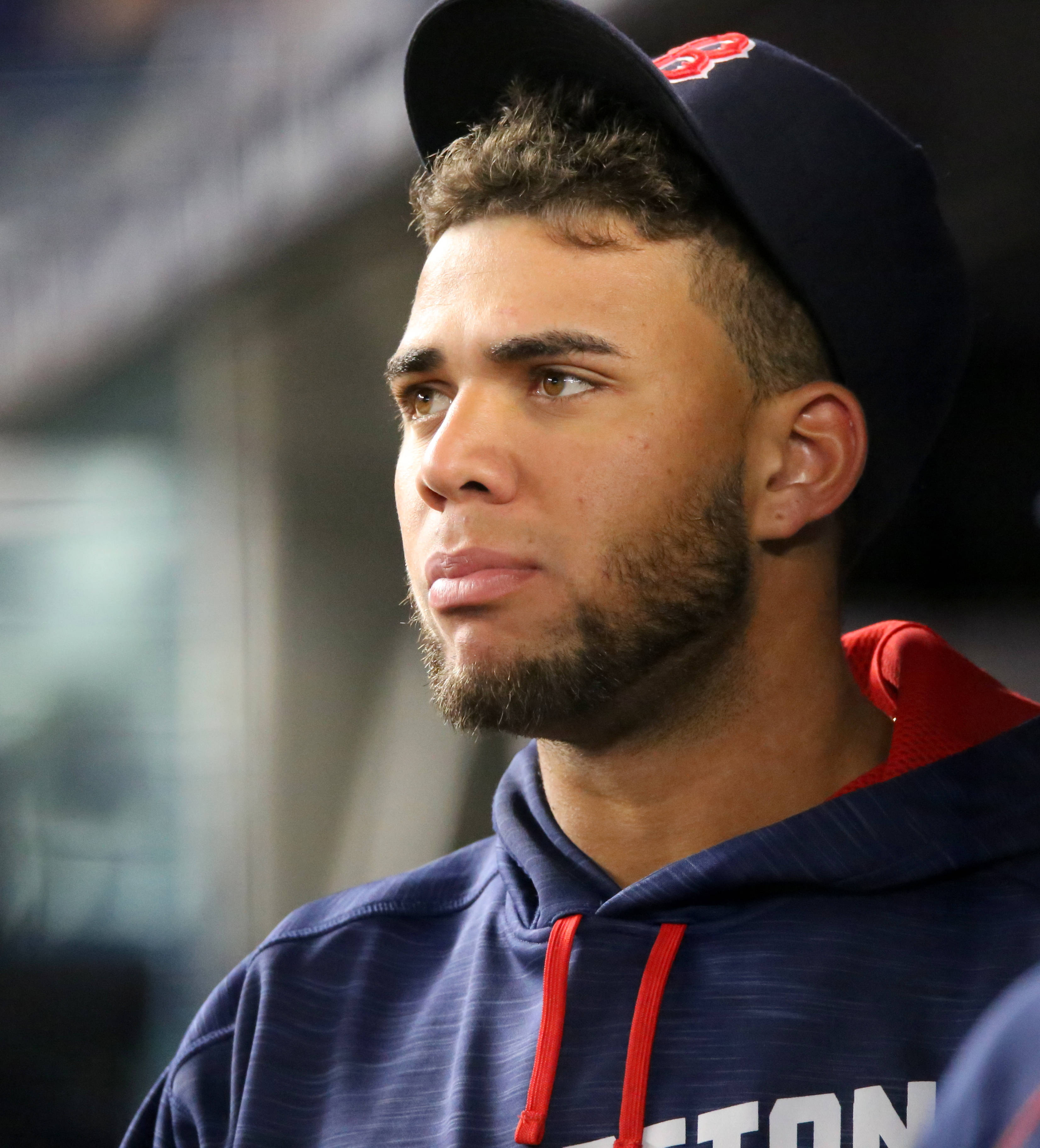 MLB Players 桌布 壁紙 — 一位專注的棒球運動員戴著海軍藍帽子和連帽衫，在比賽中專注地凝視鏡頭外。