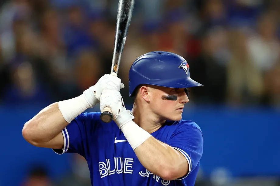 baseball bat 桌布 壁紙 — 一位專注的棒球運動員身穿藍色球衣，在球場燈光下揮棒中途緊握球棒。